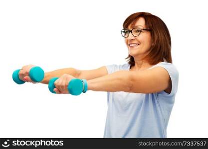 sport and old people concept - smiling senior woman with dumbbells and fitness tracker exercising over white background. smiling senior woman with dumbbells exercising