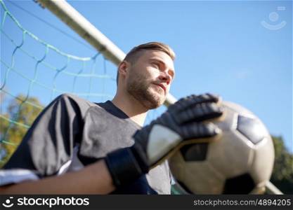 sport and people - soccer player or goalkeeper with ball at football goal on field. goalkeeper with ball at football goal on field