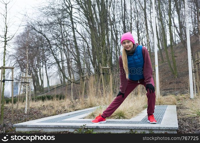 Sport and recreation. Fit slim sporty teen girl stretching warming up outdoor in park. Woman exercising on fresh air.. Sporty girl stretching outdoor in park.