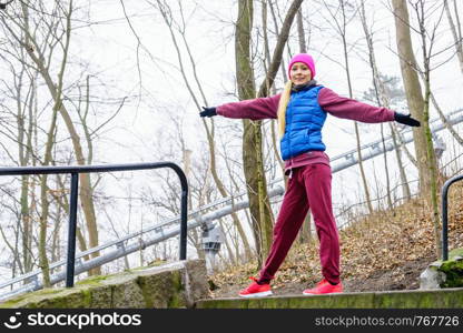 Sport and recreation. Fit slim sporty teen girl stretching warming up outdoor in park. Woman exercising on fresh air.. Sporty girl stretching outdoor in park.