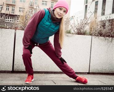 Sport and recreation. Fit slim sporty teen girl stretching warming up outdoor on city street. Woman exercising on fresh air.. Sporty girl stretching outdoor on city street.