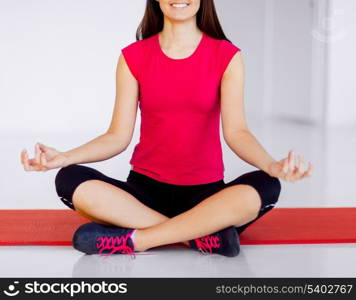 sport and yoga concept - girl sitting in lotus position and meditating