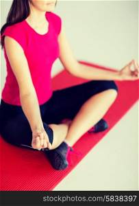 sport and yoga concept - girl sitting in lotus position and meditating