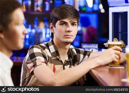 Sport bar. Two young men sitting at bar and talking