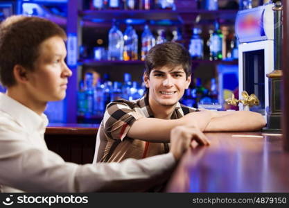 Sport bar. Two young men sitting at bar and talking