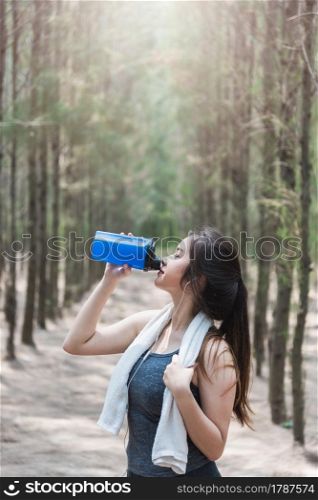 Sport beautiful young woman girl lifestyle exercise healthy drinking protein water after running workout in forest nature park with copy space
