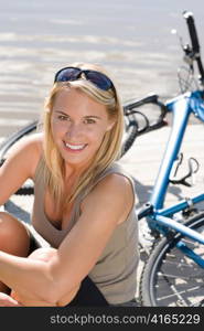 Sport biking young woman sitting on pier by natural lake