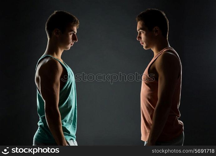 sport, bodybuilding, competition and people concept - young men looking to each other