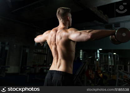 sport, bodybuilding, fitness and people concept - close up of young man with dumbbells flexing muscles in gym. close up of man with dumbbells exercising in gym