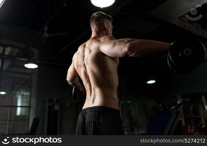 sport, bodybuilding, fitness and people concept - close up of young man with dumbbells flexing muscles in gym. close up of man with dumbbells exercising in gym