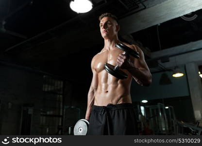 sport, bodybuilding, fitness and people concept - close up of young man with dumbbells flexing muscles in gym. close up of man with dumbbells exercising in gym