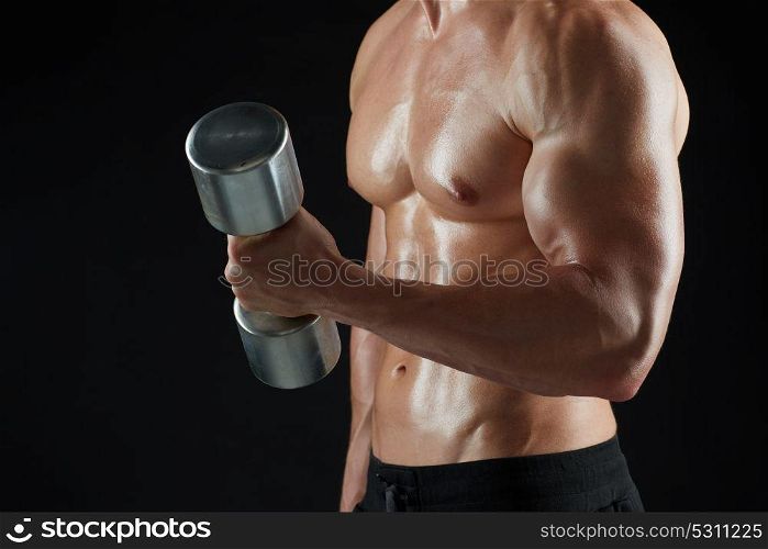sport, bodybuilding, fitness and people concept - close up of young man with dumbbells flexing muscles over black background. close up of man with dumbbells exercising