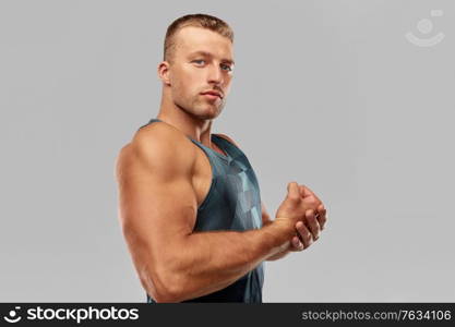 sport, bodybuilding, fitness and people concept - portrait of young man or bodybuilder showing his muscles. portrait of young man or bodybuilder