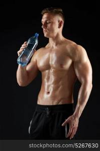 sport, bodybuilding, fitness and people concept - young man or bodybuilder with bottle of water and bare torso over black background. young man or bodybuilder with bottle of water
