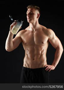 sport, bodybuilding, fitness and people concept - young man or bodybuilder with protein shake bottle and bare torso over black background. young man or bodybuilder with protein shake bottle