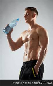 sport, bodybuilding, fitness and people concept - young man or bodybuilder with bottle of water and bare torso. young man or bodybuilder with bottle of water
