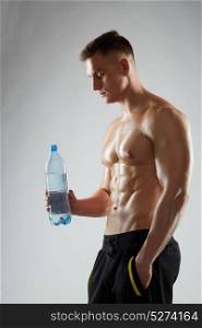 sport, bodybuilding, fitness and people concept - young man or bodybuilder with bottle of water and bare torso. young man or bodybuilder with bottle of water