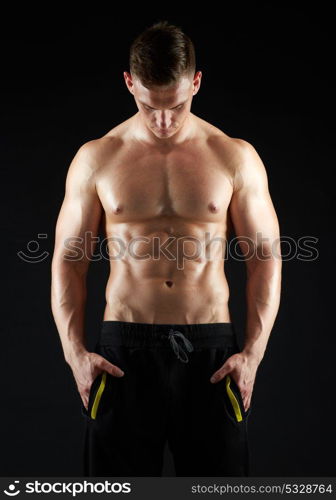 sport, bodybuilding, fitness and people concept - young man or bodybuilder with bare torso over black background. young man or bodybuilder with bare torso