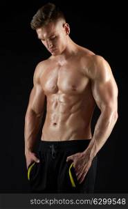 sport, bodybuilding, fitness and people concept - young man or bodybuilder with bare torso over black background. young man or bodybuilder with bare torso