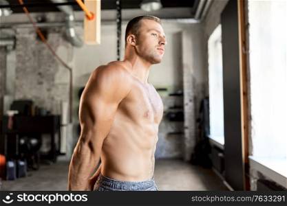 sport, bodybuilding, fitness and people concept - young man with bare torso in gym. young man with bare torso in gym