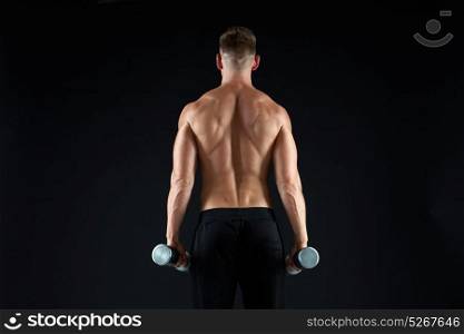 sport, bodybuilding, fitness and people concept - young man with dumbbells flexing muscles over black background from back. man with dumbbells exercising