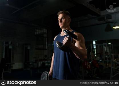 sport, bodybuilding, fitness and people concept - young man with dumbbells flexing muscles in gym. young man with dumbbells exercising in gym