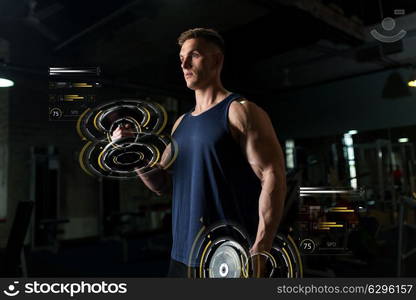 sport, bodybuilding, fitness and people concept - young man with dumbbells flexing muscles in gym. young man with dumbbells exercising in gym