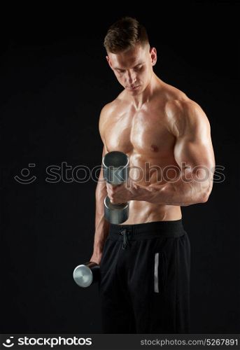 sport, bodybuilding, fitness and people concept - young man with dumbbells flexing muscles over black background. man with dumbbells exercising