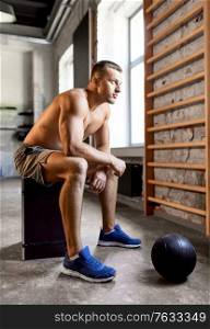 sport, bodybuilding, fitness and people concept - young man with medicine ball in gym. young man with medicine ball in gym