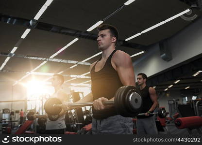 sport, bodybuilding, lifestyle and people concept - group of men with barbell flexing muscles in gym