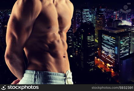 sport, bodybuilding, strength and people concept - close up of male bodybuilder bare torso over night city background