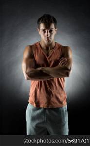 sport, bodybuilding, strength and people concept - young man standing over gray background