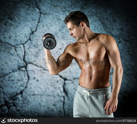 sport, bodybuilding, training and people concept - young man with dumbbell flexing biceps over concrete wall background