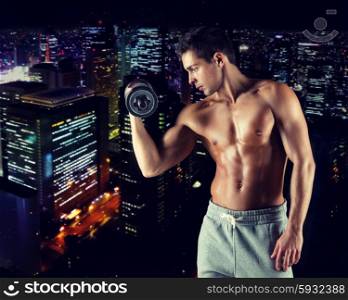 sport, bodybuilding, training and people concept - young man with dumbbell flexing biceps over night city background