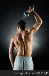 sport, bodybuilding, training and people concept - young man with dumbbell flexing muscles over gray background