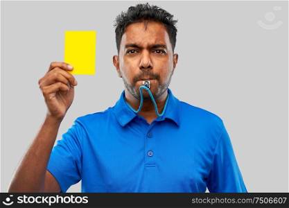 sport, caution, game and football concept - indian referee whistling and showing yellow card. indian referee whistling and showing yellow card