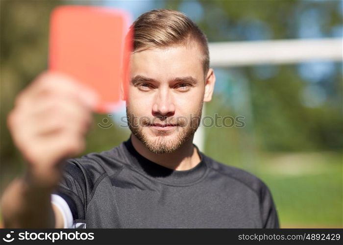 sport, caution, game and people - referee on football field showing red card