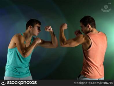 sport, competition, strength and people concept - young men fighting hand-to-hand over dark background
