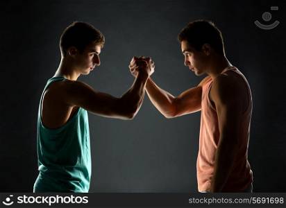 sport, competition, strength and people concept - young men wrestling