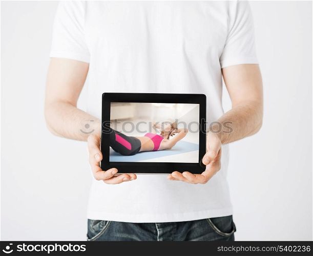 sport concept - man holding tablet pc with picture of woman doing exercise