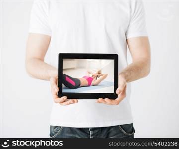 sport concept - man holding tablet pc with picture of woman doing exercise
