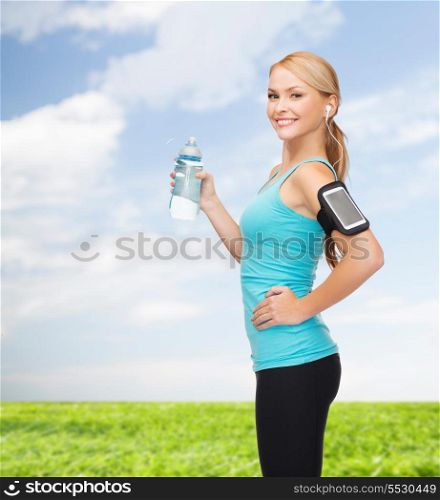 sport, excercise, technology, internet and healthcare - sporty woman listening to music from smartphone with water bottle
