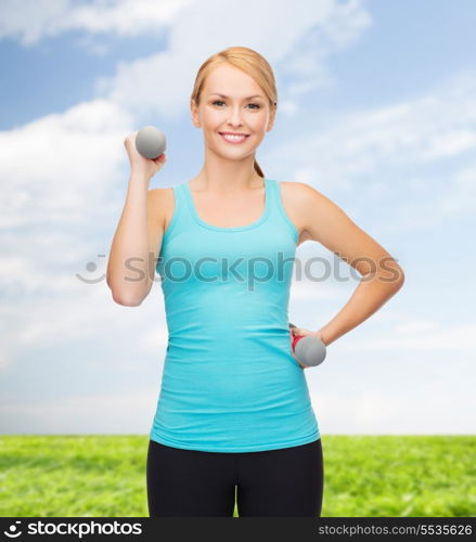 sport, excercising and healthcare concept - young sporty woman with light dumbbells