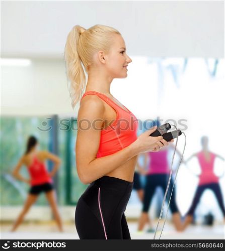 sport, exercise and healthcare concept - smiling sporty woman with skipping rope