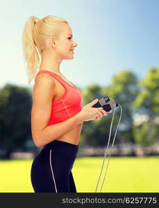 sport, exercise and healthcare concept - smiling sporty woman with skipping rope