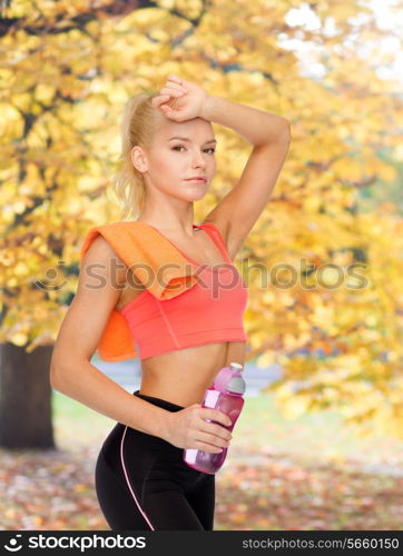 sport, exercise and healthcare concept - tired sporty woman with orange towel and water bottle