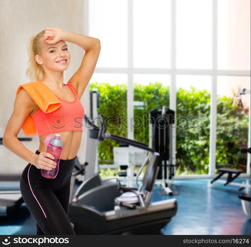 sport, exercise and healthcare - smiling sporty woman with orange towel and water bottle