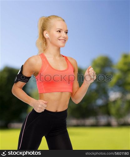 sport, exercise, technology, internet and healthcare - smiling sporty woman running and listening to music from smartphone