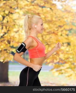 sport, exercise, technology, internet and healthcare - smiling sporty woman running and listening to music from smartphone