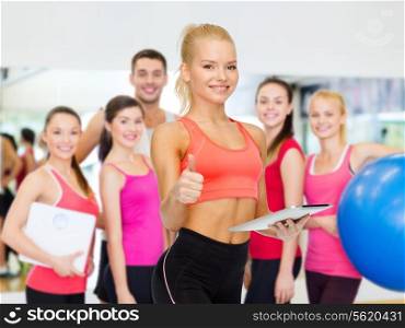 sport, exercise, technology, internet and healthcare - smiling sporty woman with tablet pc computer showing thumbs up